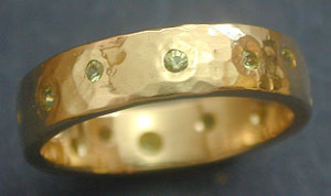 5mm wide 14kt Yellow gold hammered band. Various size peridot flush set around the band. Starting at $645